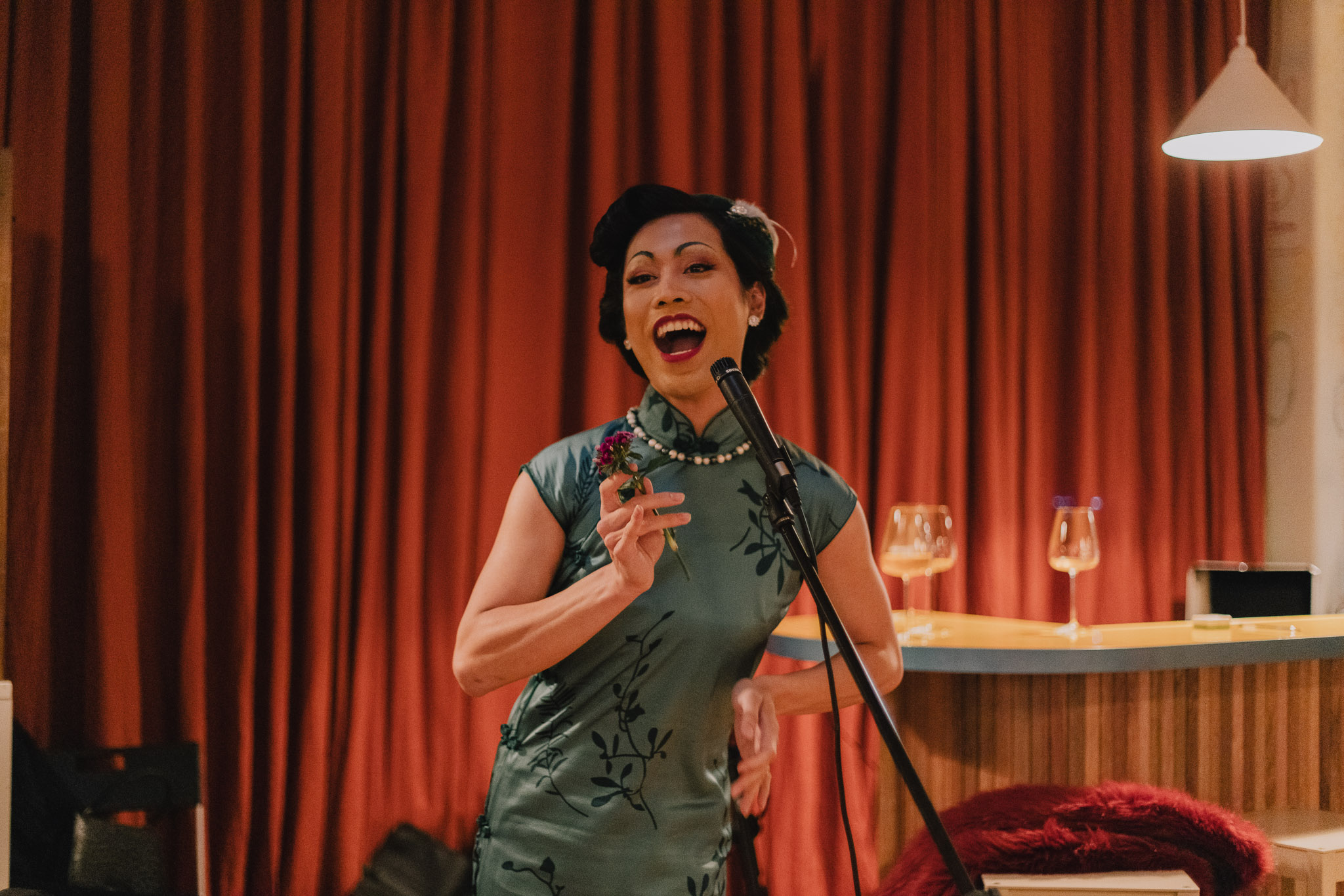 image of a performer wearing a cheongsam and lip syncing into the microphone