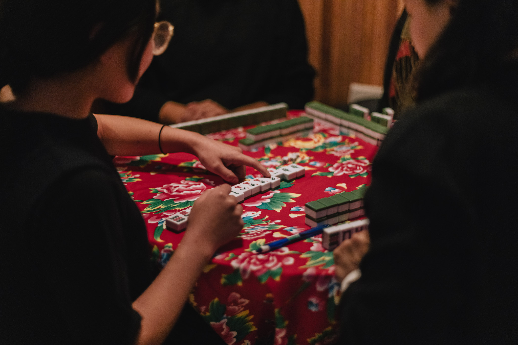 image of four people playing Mah Jong at the table